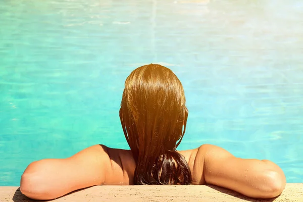 Vista posteriore della donna rilassata in piscina con acqua blu — Foto Stock