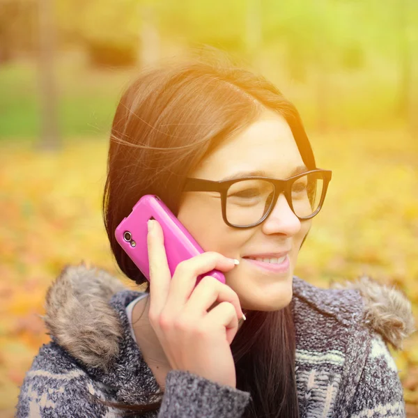Schöne lächelnde Studentin, die auf dem Handy spricht — Stockfoto