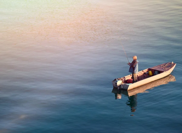 Rybak stojący na łodzi i wędkowanie w morzu — Zdjęcie stockowe