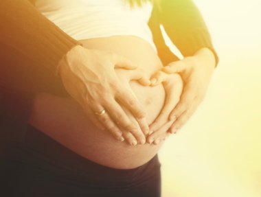 hamile çift elle kalp şekil verme göbek çevresinde