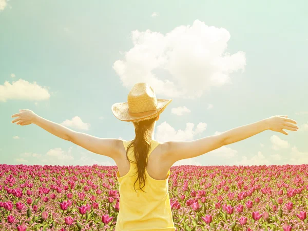 Mädchen breitet ihre Arme inmitten eines Tulpenfeldes aus - genießen Sie nat — Stockfoto