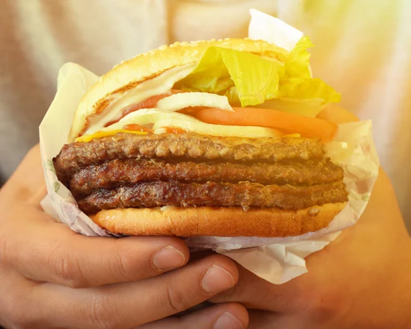 Manos sosteniendo gran sabor Hamburguesa con queso — Foto de Stock