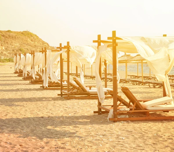 Row of luxurious beds on beach resort — Stock Photo, Image