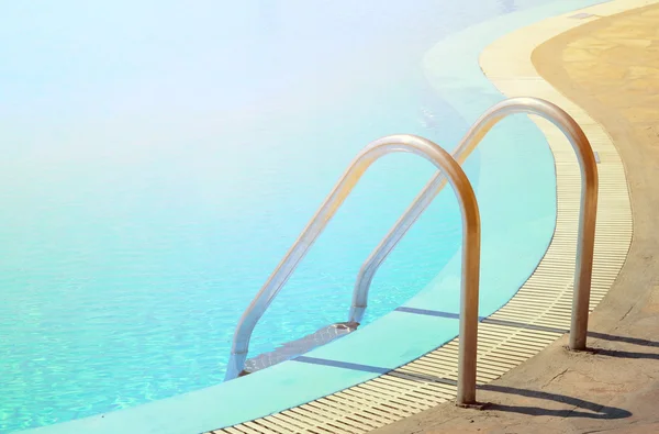 Плавательный бассейн с изогнутыми лестницами — стоковое фото