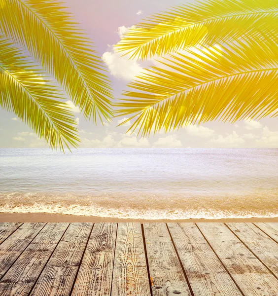 Mer tropicale et plage avec feuilles de palmier et plancher en bois — Photo