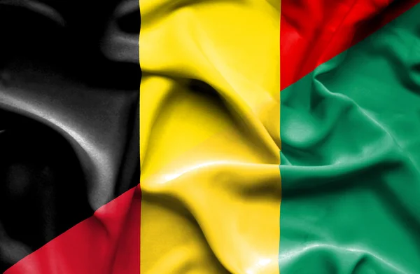 Waving flag of Guinea and Belgium — Stock Photo, Image