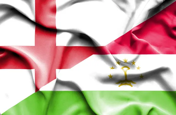Tádzsikisztán és Anglia hullámzó zászlaja — Stock Fotó