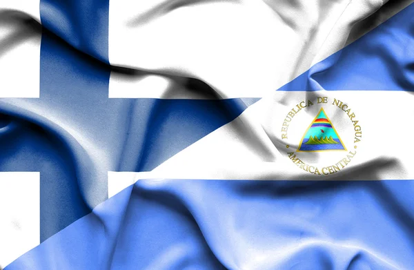 Flagge Nicaraguas und Finnlands schwenkend — Stockfoto