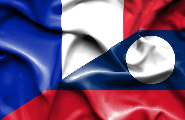Vlající vlajka Laosu a Francie — Stock fotografie