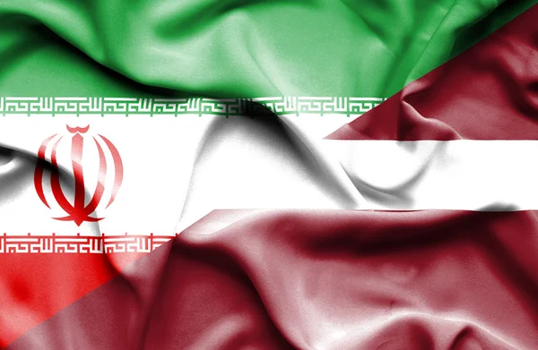 Lettország és Irán hullámzó zászlaja — Stock Fotó