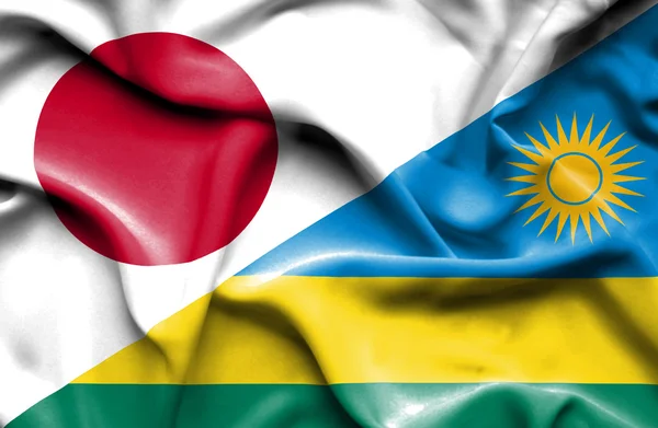 Wapperende vlag van Rwanda en Japan — Stockfoto