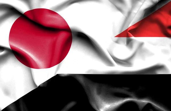 Flagge des Jemen und Japans schwenkend — Stockfoto