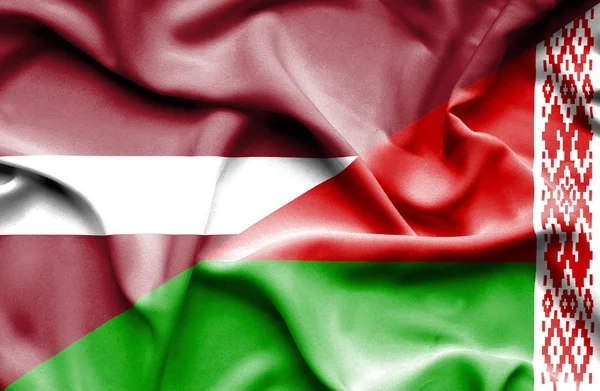 Fehéroroszország és Lettország hullámzó zászlaja — Stock Fotó