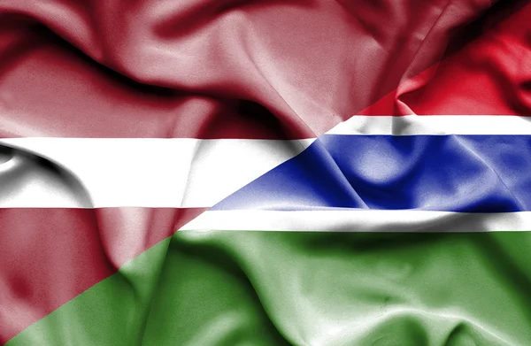 Waving flag of Gambia and Latvia — Stock Photo, Image