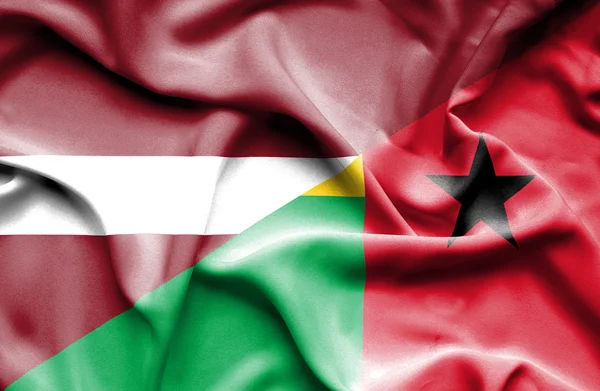 Wapperende vlag van Guinee-Bissau en Letland — Stockfoto