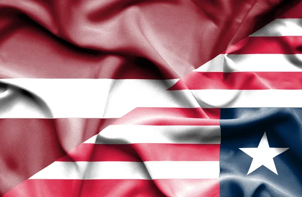 Waving flag of Liberia and Latvia — Stock Photo, Image