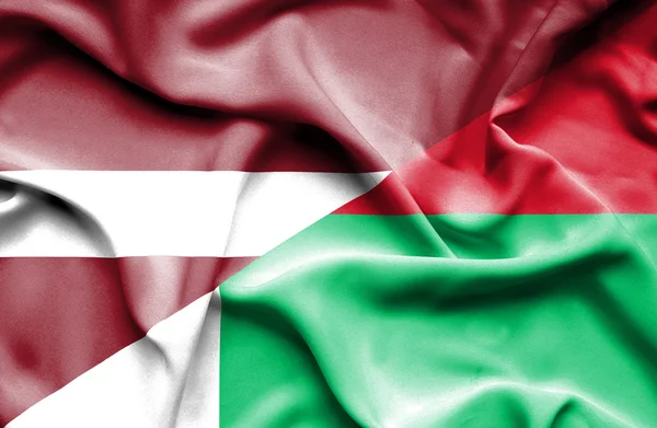 Waving flag of Madagascar and Latvia — Stock Photo, Image