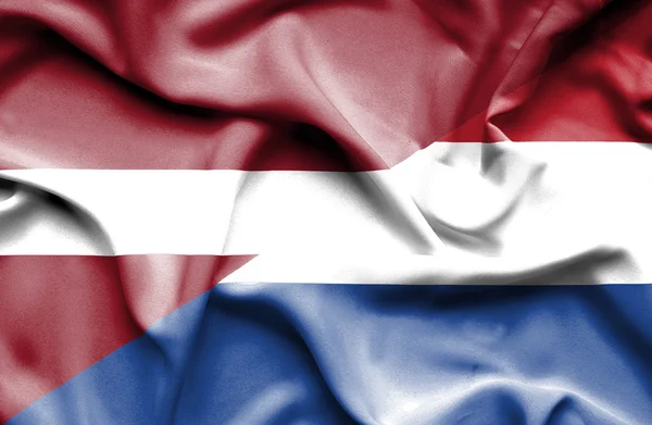 Waving flag of Netherlands and Latvia — Stock Photo, Image