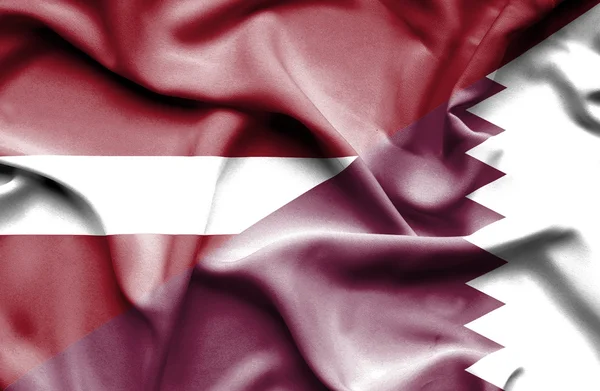 Waving flag of Qatar and Latvia — Stock Photo, Image