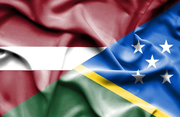Salamon-szigeteki és Lettország hullámzó zászlaja — Stock Fotó