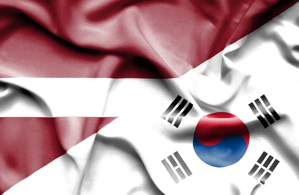 Waving flag of South Korea and Latvia — Stock Photo, Image