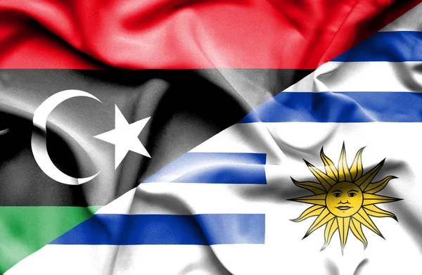 Waving flag of Uruguay and Libya — Stock Photo, Image