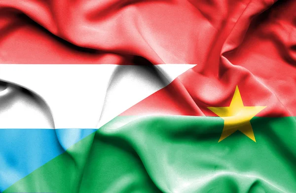 Burkina Faso és Luxemburg hullámzó zászlaja — Stock Fotó