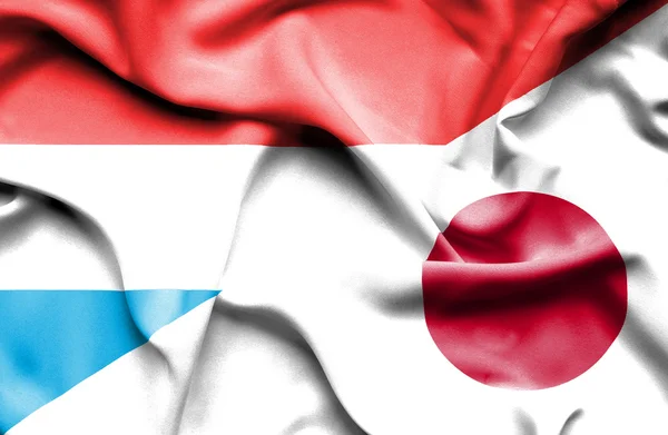 Integetett a japán és Luxemburg zászlaja — Stock Fotó