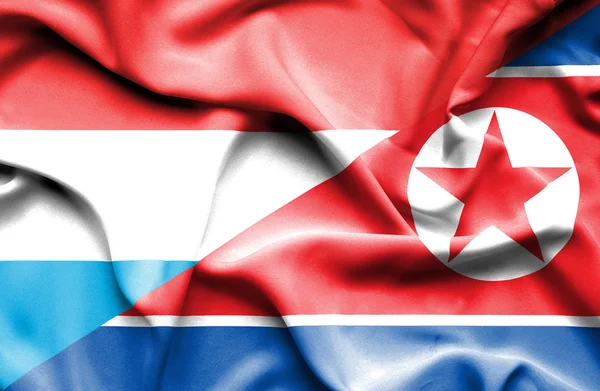 Flagge Nordkoreas und Luxemburgs schwenken — Stockfoto