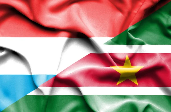 Flagge von Surinam und Luxemburg schwenken — Stockfoto