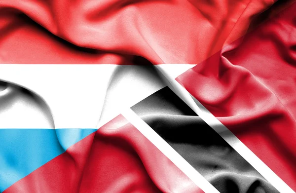 Flagge von Trinidad und Tobago und Luxemburg schwenken — Stockfoto