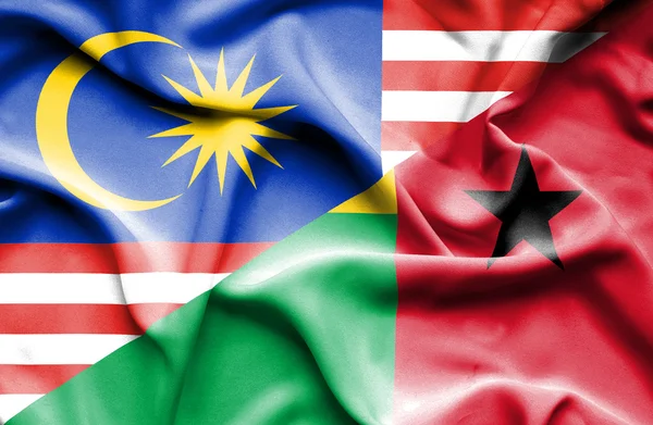 기니 비사우와 말레이시아의 국기를 흔들며 — 스톡 사진