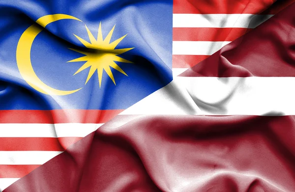 라트비아와 말레이시아의 국기를 흔들며 — 스톡 사진