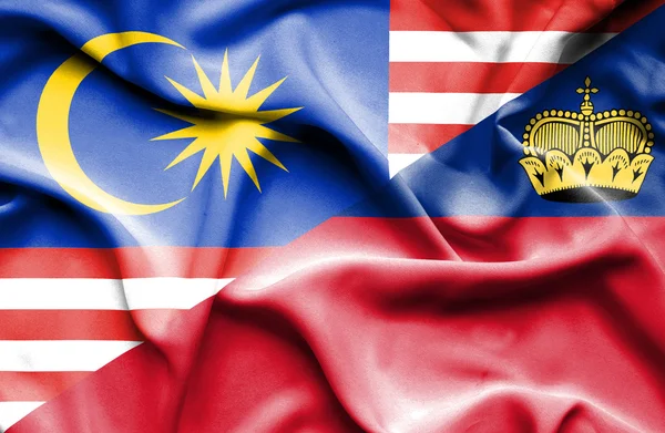 Bølgende flag af Lichtenstein og Malaysia - Stock-foto