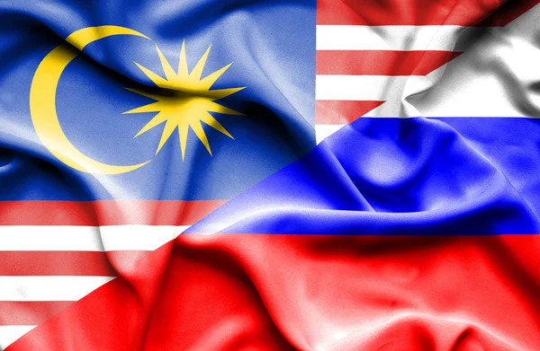 Macha flagą Rosji i Malezji — Zdjęcie stockowe