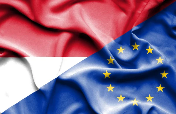 Размахивая флагом Европейского Союза и Монако — стоковое фото