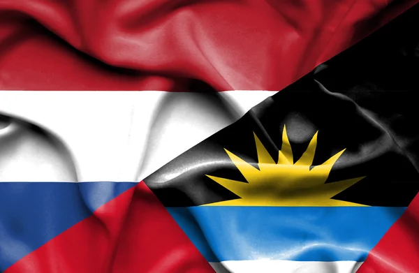 Vlající vlajka Antiguy a Barbudy a Nizozemsko — Stock fotografie