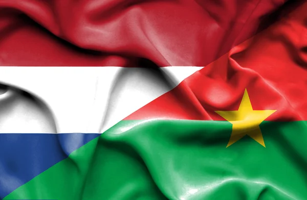 Wapperende vlag van burkina faso en Nederland — Stockfoto