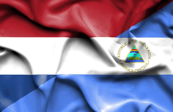 Wapperende vlag van nicaragua en Nederland — Stockfoto