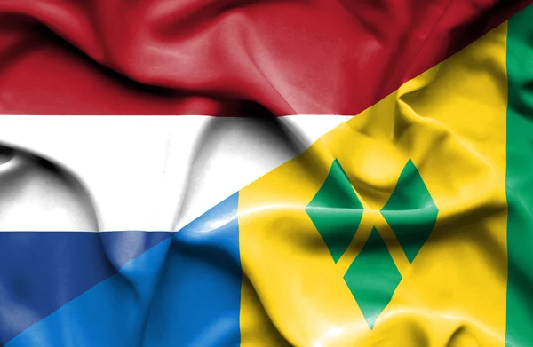 Wapperende vlag van saint vincent en grenadines en Nederland — Stockfoto