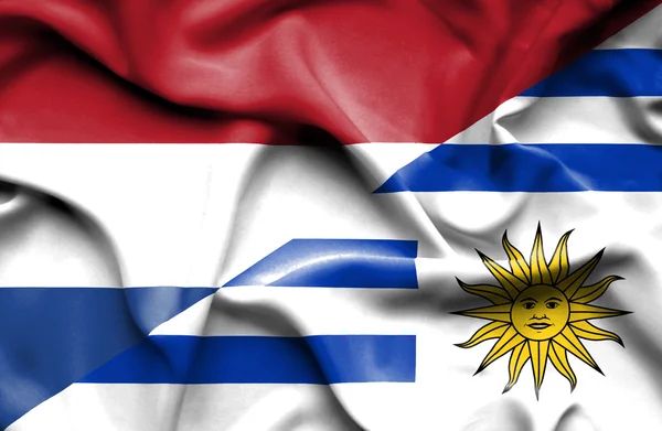 Waving flag of Uruguay and Netherlands — Stock Photo, Image