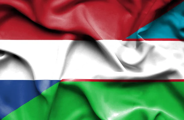 ウズベキスタン ・ オランダの旗を振っています。 — ストック写真