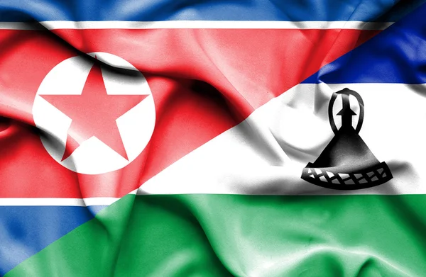 Flagge von Lesotho und Nordkorea schwenken — Stockfoto