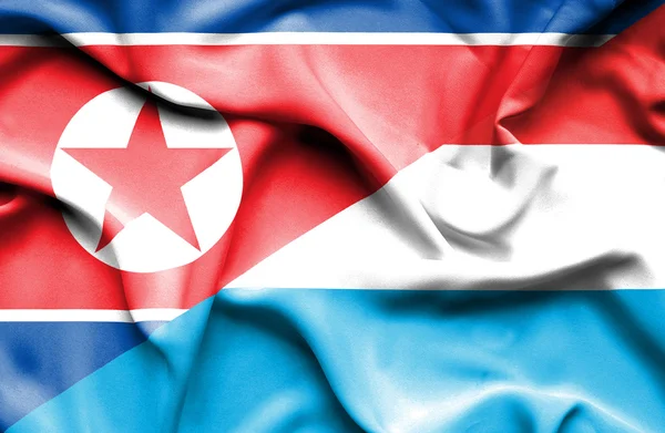 Flagge Luxemburgs und Nordkoreas schwenken — Stockfoto