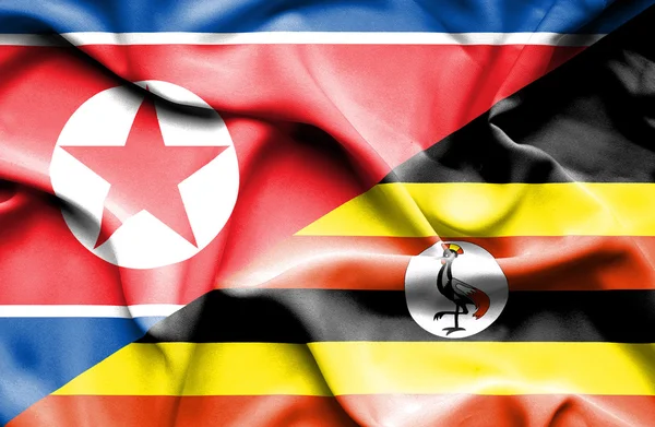 ウガンダと北朝鮮の旗を振っています。 — ストック写真