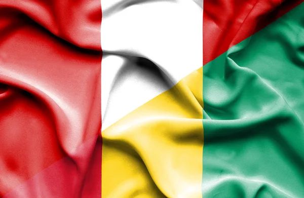 Waving flag of Guinea and Peru — Stock Photo, Image