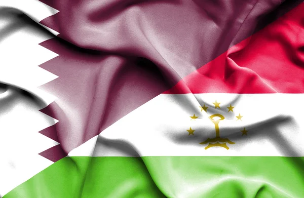 Waving flag of Tajikistan and Qatar — Stock Photo, Image