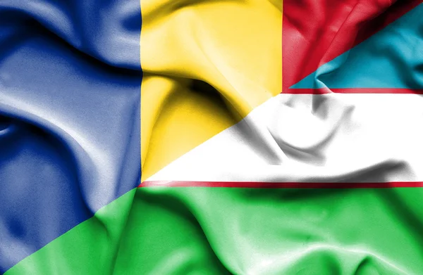 Waving flag of Uzbekistan and Romania — Stock Photo, Image