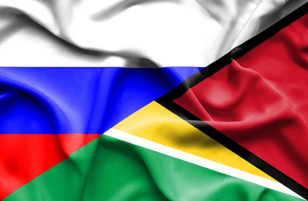 Waving flag of Guyana and Russia — Stock Photo, Image