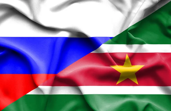 Waving flag of Suriname and Russia — Stock Photo, Image